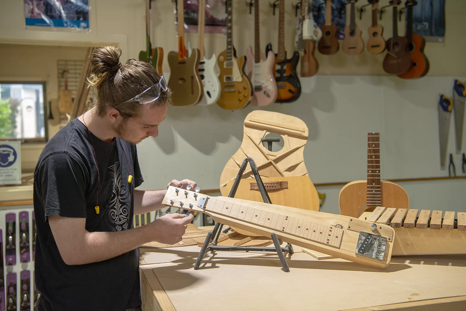 Certificate III in Musical Instrument Making and Maintenance student working on a guitar neck.